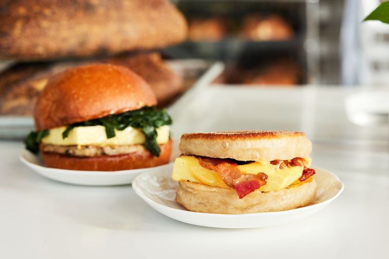 Washington – English Muffin Layered with Bacon, Egg, Smoked Cheddar, and Arugula